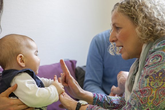 Therapeutin Heike Brosch mit einem Baby und deren Eltern in der Therapiesituation.