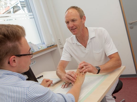 Handchirurg Volker Buhmann untersucht die Hand eines Patienten
