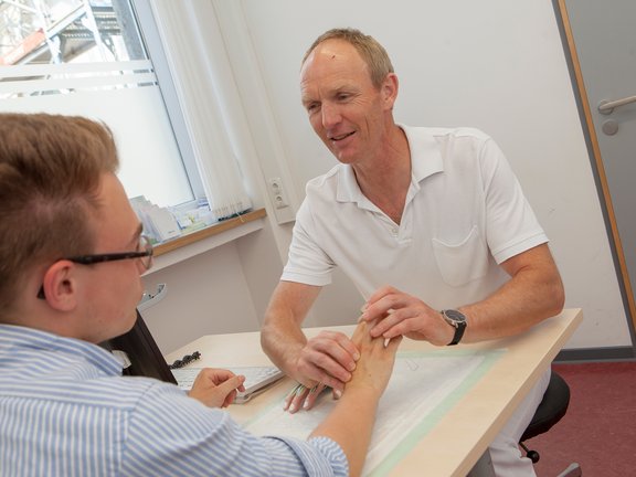Handchirurg Volker Buhmann untersucht die Hand eines Patienten