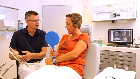 Mund-Kiefer-Gesichtschirurg Dr. Dr. Alexander Tschakaloff im Gespräch mit einer Patientin 