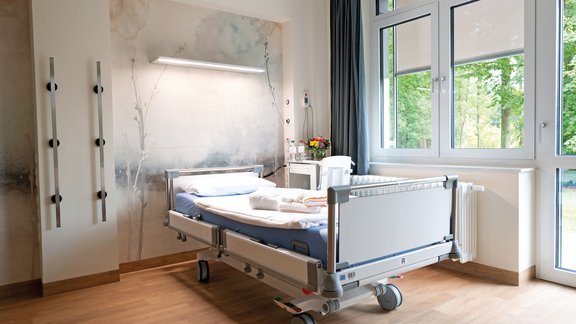 Freundliches Einzelzimmer mit Krankenbett der Komfortstation inklusive Wahlleistungsartikeln