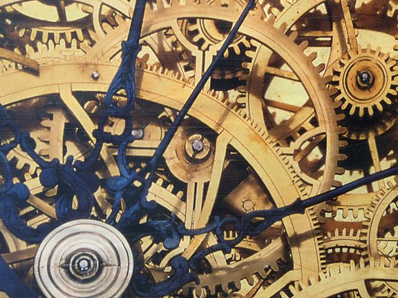 Zahnräder einer Uhr greifen ineinander, darüber sind blaue Zeiger abgebildet