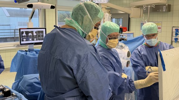 Ärzte im OP analysieren am Monitor Daten