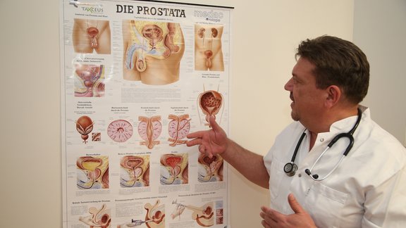 Urologe Agim Ismani erklärt anhand einer Prostata-Schautafel.