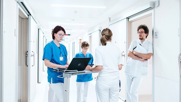 Ärzteteam und Pflegefachpersonal besprechen sich.