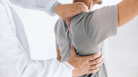 Arzt untersucht Patienten an der Schulter