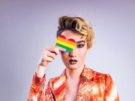 Person hält Transgenderherz vor dem Auge