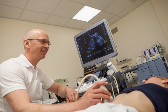 Leitender Arzt der Gefäßchirurgie Dr. med. Jörn Pfeiffenberger untersucht eine Patientin per Sonografie.