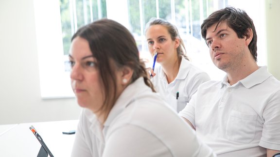 MedizinerInnen hören bei einer Fachveranstaltung interessiert zu.