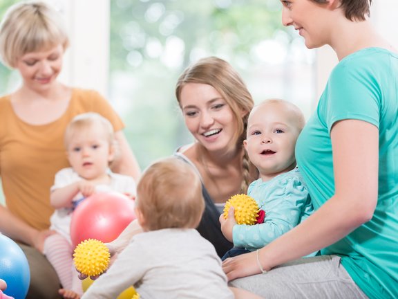 Mütter und Babys beim Turnen mit Bällen