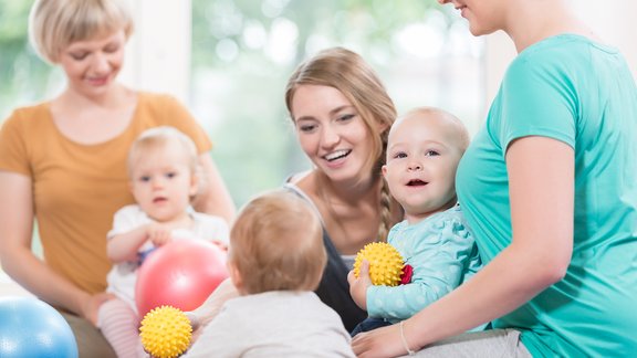 Mütter und Babys beim Turnen mit Bällen