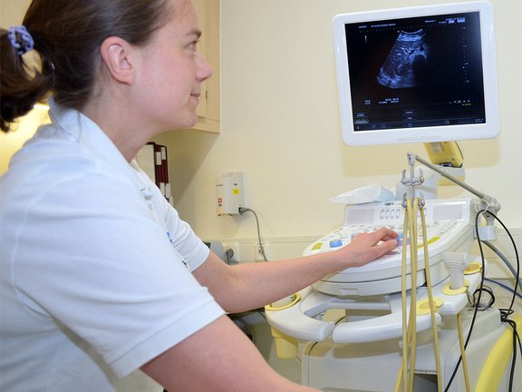 Eine Ärztin schaut während einer Sonographie auf einen Bildschirm